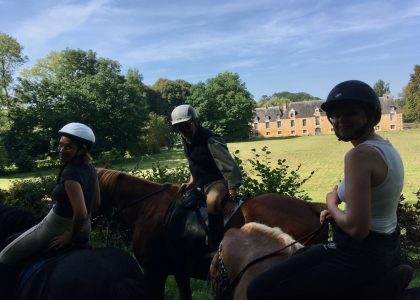 cavaliers à cheval à la découverte de châteaux lors de la randonnée équestre